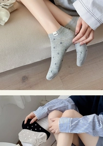 Detail of cotton ankle socks with polka dot patterns and branded tags in neutral tones