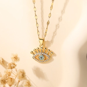 Gold plated evil eye necklace with blue and clear zircon crystals on a fine chain