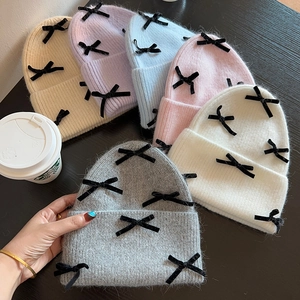 Collection of warm knitted beanies with velvet bows in beige, pink, blue and more colors