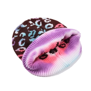 Close-up of thick ribbed knit texture and colorful leopard tie-dye pattern on winter beanie