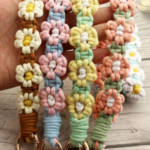 Handmade woven daisy flower keychain in four color schemes with golden metal clasp