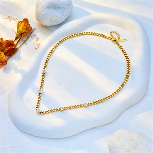 Golden titanium steel thick chain necklace with crystal heart charms on a white tray