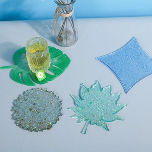 DIY crystal resin coasters in leaf and geometric shapes with glitter and gold foil accents