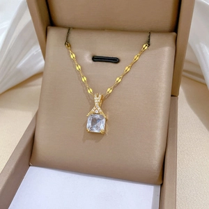 Detail of gold pendant necklace with rectangular crystal on brown velvet gift box