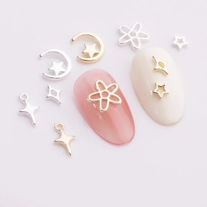Golden and silver star moon nail art decorations on soft pink manicure tips