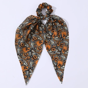 Détail du chouchou d'Halloween avec rubans à motifs de citrouilles et crânes