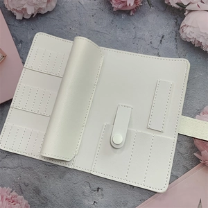 Detailed view of white PU leather nail drill bit organizer roll on a stylish desktop