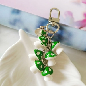 Close-up of seven green spotted mushroom charms on a keychain with I am beautiful tag
