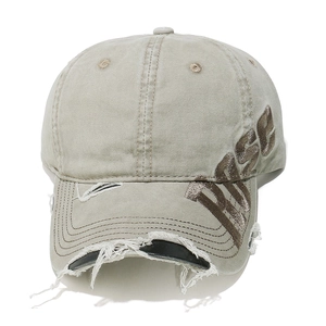 Close-up of vintage washed canvas baseball cap with distressed rips and ROSE embroidery