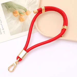 Close-up of red PU leather keychain with gold lobster clasp on artistic background