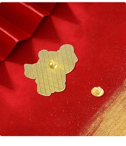 Detail of golden metal brooch back featuring anti-slip cross texture and butterfly clutch