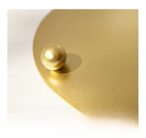 Macro view of matte gold metal candle tray base with heat-resistant raised design