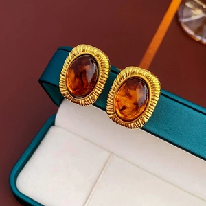 Detailed view of vintage amber resin earrings with textured gold-tone metal base settings