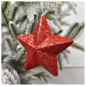 Close-up of red glitter star Christmas tree ornament with elegant white hanging ribbon