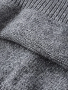 Macro view of grey knit fabric texture with soft ribbed edge and high-quality wool fibers