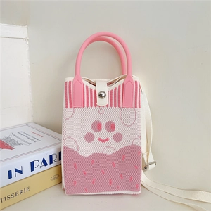 Detail of knitted phone bag with cat paw pattern showing pink handle and white strap