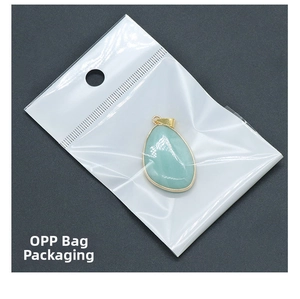 Detail of light green drop-shaped crystal pendant with gold rim in a clear OPP bag