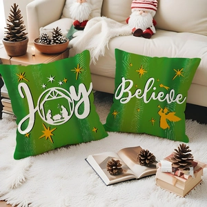 Close-up of green Christmas pillow covers with gold Joy and Believe holiday prints
