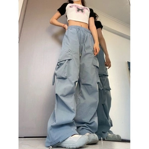 Detail of light blue cargo pants with side pockets and elastic drawstring waist on model