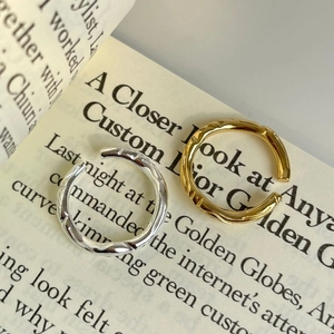Macro shot of 925 sterling silver hammered rings in gold and silver on vintage paper