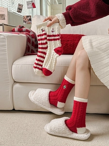 Detail of warm red and beige Christmas socks with cute embroidery in a cozy winter setting