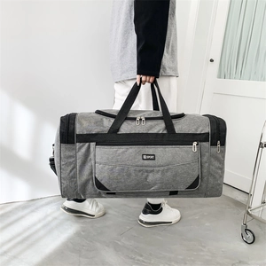 Large capacity gray nylon travel bag with SPORT label shown in a modern interior setting