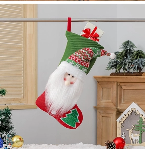 Detail of red and green knitted Santa Christmas stocking with a small gift box inside