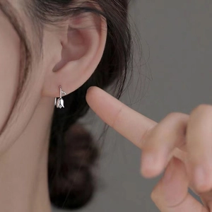 Elegant silver tulip flower hoop earrings for women shown on model in a minimalist style