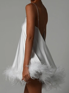 Détail de la robe en satin blanc avec ourlet en plumes d'autruche et fines bretelles en chaîne