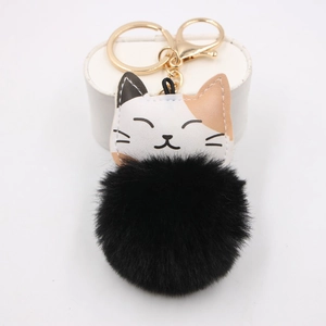 Detailed view of lucky cat plush keychain featuring a fluffy black faux fur pompom ball