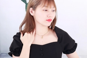 Detailed view of a gold heart pendant necklace worn on a model for a stylish look