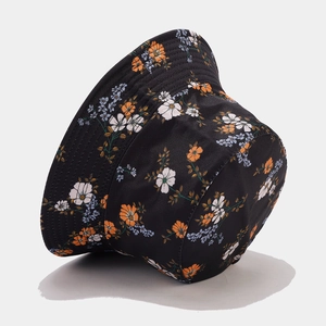Close-up of the black twill cotton bucket hat featuring small floral patterns in orange and blue