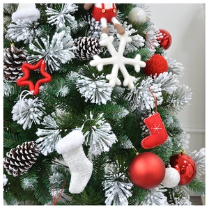 Detail of Christmas tree ornaments with red felt stockings and white snowflake charms