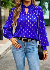 Detail of blue chiffon blouse with gold polka dots featuring a V-neckline with ties