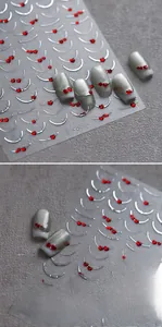 Détail macro de stickers ongles M-919 avec coeurs rouges 3D et courbes argentées