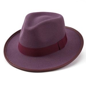 Detailed macro view of dark purple felt fedora hat with burgundy brim and decorative band