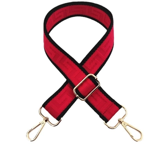 Detail of adjustable red and black nylon strap with geometric patterns and gold buckles