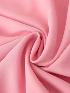Detail of pink chiffon fabric showing soft layered ruffles and smooth textile texture