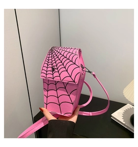 Close-up of pink coffin-shaped crossbody bag featuring a black spider web pattern
