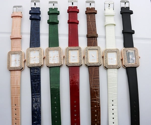Detail view of seven rectangular quartz watches with diamond bezels and leather straps