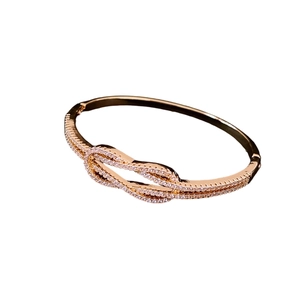 Bracelet nœud élégant plaqué or rose avec pavé de zircons scintillants sur fond blanc