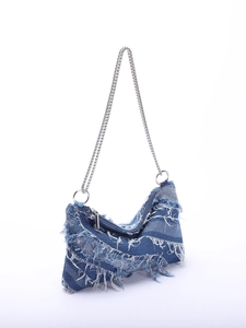 Close-up of blue denim texture with fringe details and silver metal chain strap