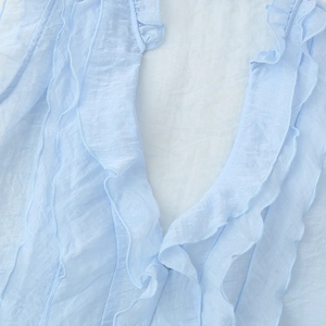 Light blue sleeveless blouse with feminine ruffles and lightweight textured fabric details