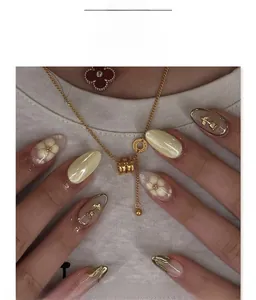 Détails de faux ongles 3D rose dorée de forme amande avec un design floral élégant