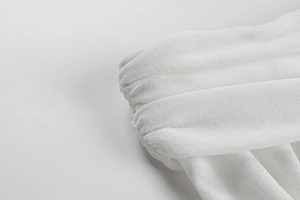 Détail rapproché du tissu froncé blanc avec de fines textures plissées sur la robe