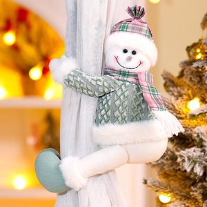 Detail of Christmas snowman curtain buckle with green cable knit sweater on white sheer