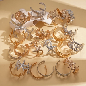 Golden and silver ocean starfish seashell bangles set on sandy beach decor background