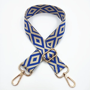 Detail of embroidered geometric diamond pattern on bag strap with gold metal lobster hooks