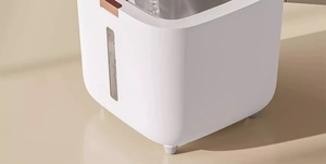 Detail of water filling into white storage container with visible transparent water level window