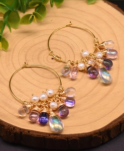 Detail of handmade gold hoop earrings with freshwater pearls and colorful Czech beads